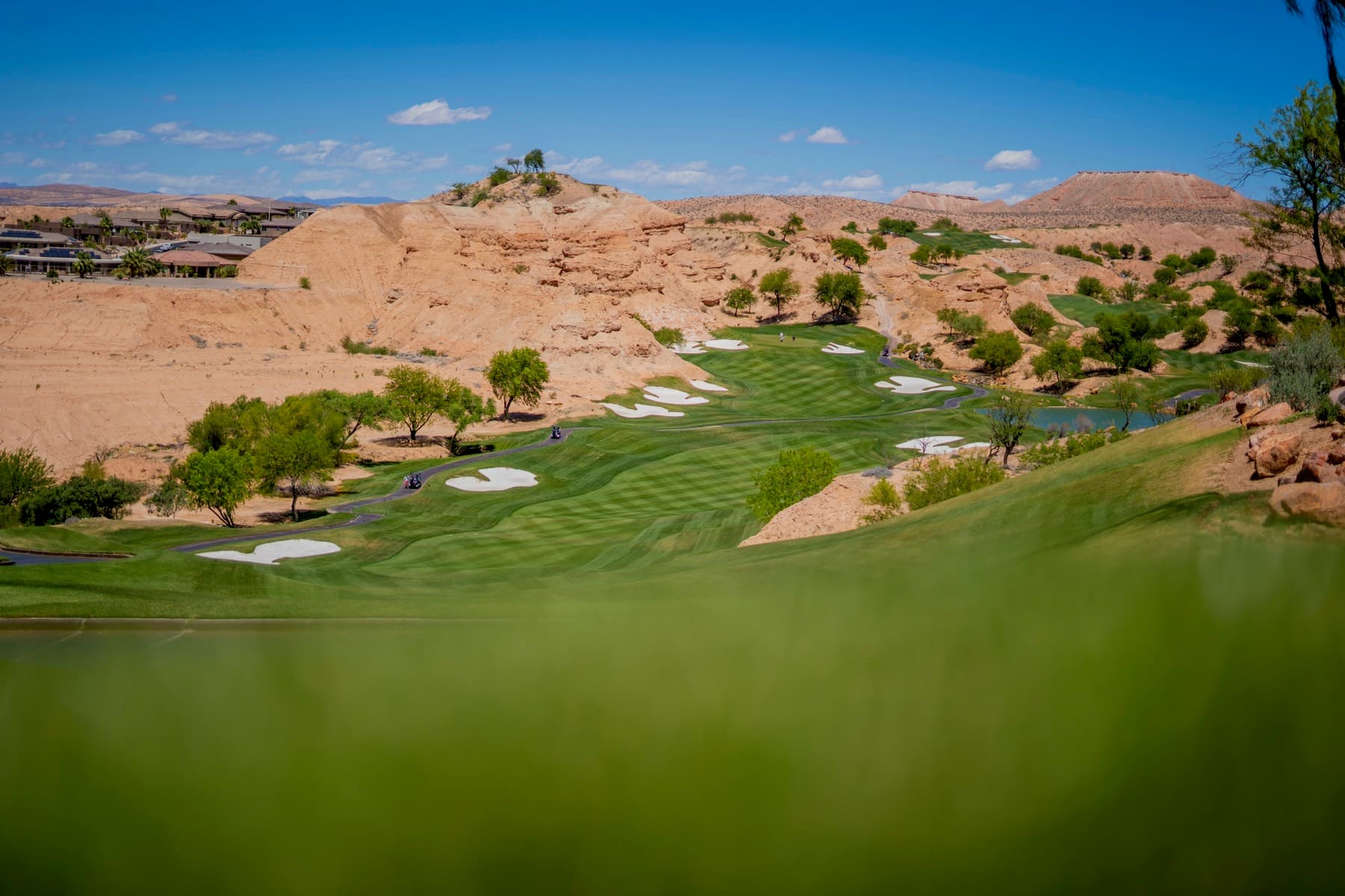 A desert golf course framed by red rock hills and green fairways.
